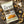 Load image into Gallery viewer, A bag of EPIC Provisions' Sea Salt and Pepper Pork Rinds laying on a rustic wooden table. Next to the bag of pork rinds is actual pork rinds, sea salt, and pepper.