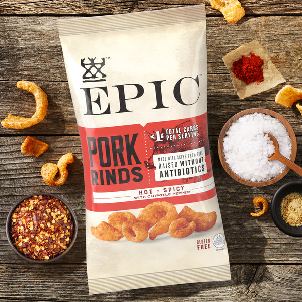 A bag of EPIC Hot and Spicy Pork Rinds around the ingredients that go in the product.